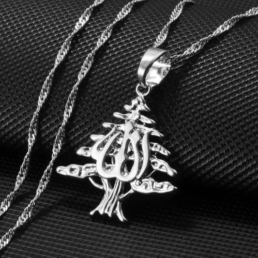 Gold cedar tree pendant necklace featuring intricate Arabic calligraphy, blending Lebanese heritage with artistic elegance for a bold statement piece.